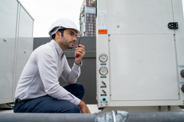 Engineer man or technician sit and  use walkie talkie to contact his team for maintenance of tank system in construction site.